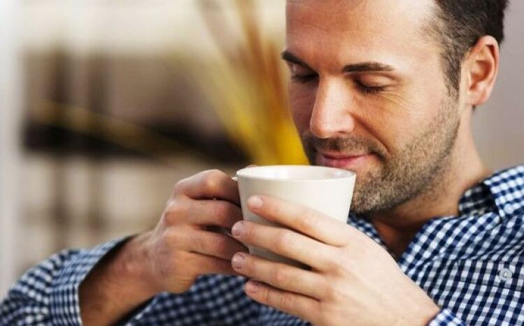 Un hombre bebe un trago de té de hierba de sauce para aumentar la potencia. 